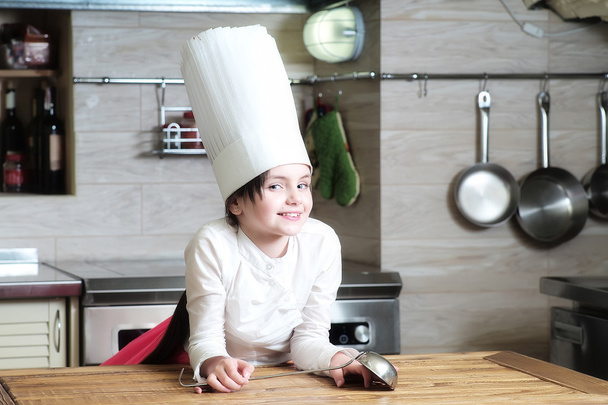 Girl in kitchen with ladle - Фото, изображение