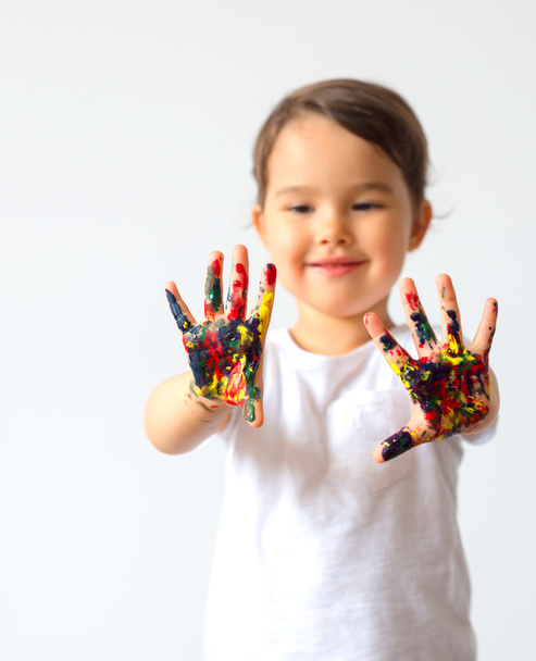 τα χέρια της μικρό παιδί βαμμένα σε πολύχρωμα χρώματα - Φωτογραφία, εικόνα