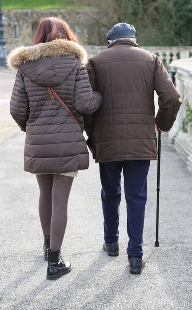 daughter walk together to the elderly father walking with stick - Photo, Image