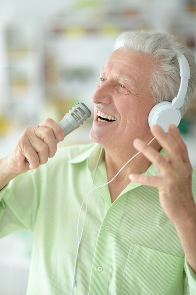 Senior man in headphones singing - Foto, Imagen