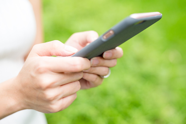 Mujer enviando SMS en el teléfono móvil
 - Foto, imagen