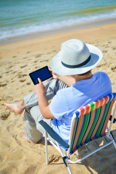 Business man using tablet computer, tropical beach outdoors. Back view - Foto, afbeelding