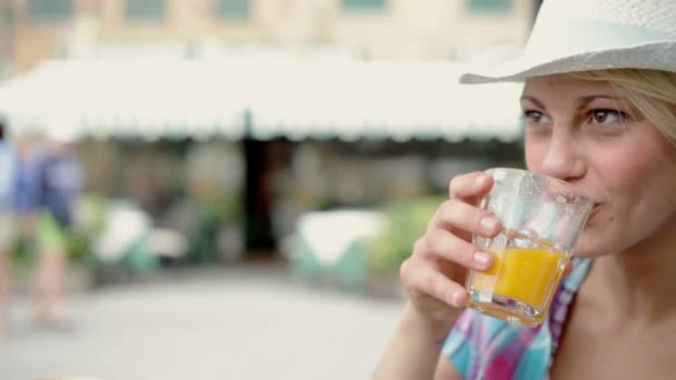 Nuori blondi nainen juo appelsiinimehua
  - Materiaali, video