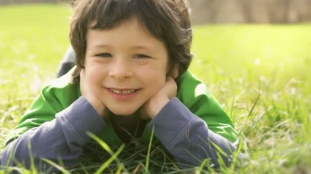 glückliches Kind aus nächster Nähe schminken Gesichter auf Gras legen  - Filmmaterial, Video