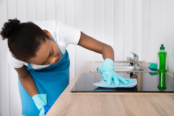 Female Janitor Cleaning Induction Stove - Foto, Bild