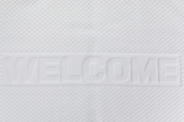 мягкое белое хлопковое полотенце с буквой "WELCOME"
 - Фото, изображение