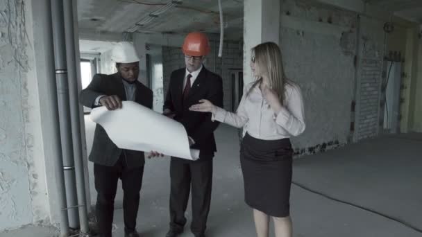Man, woman, african american in suit and hard hat consider blueprint inside construction site - Filmmaterial, Video