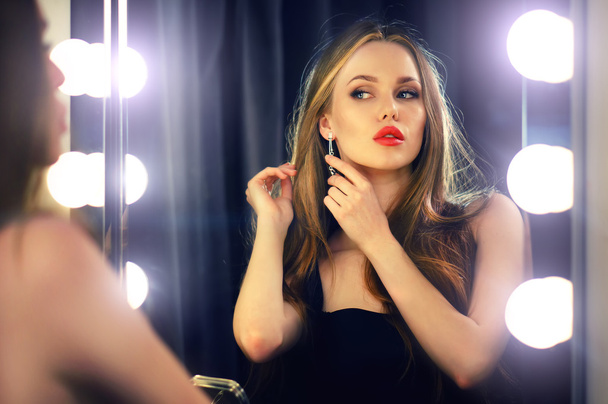 Young caucasian woman looking into makeup mirror at herself and enjoying her time. - Fotó, kép