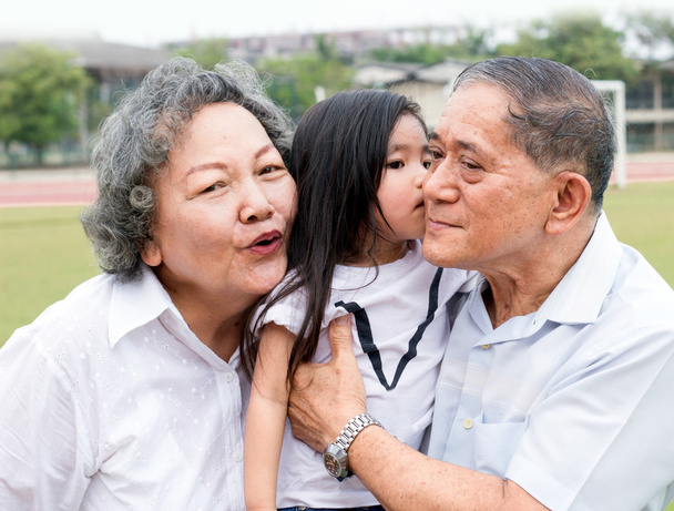 азіатський дідусь і бабуся обіймають дітей
 - Фото, зображення