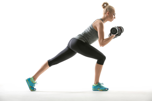 Athletic girl does exercise with dumbbells - Foto, Imagem