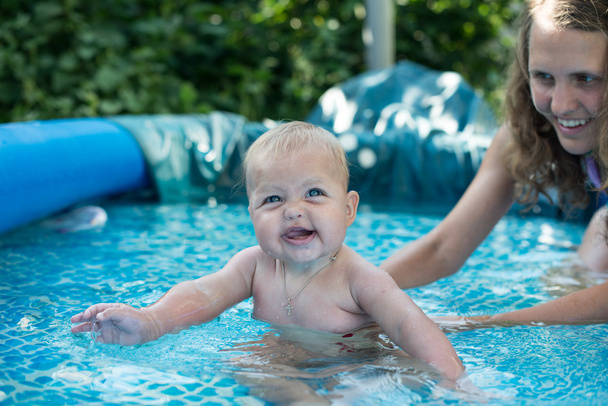 スイミング プールの側面にあるリラックスかわいい幸せな若い女の子赤ちゃん - 写真・画像