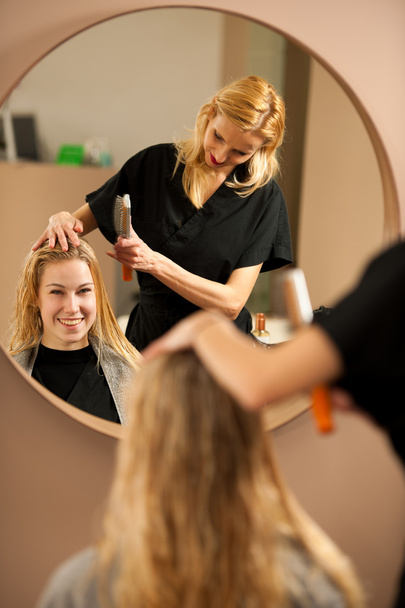 professional hair stylist at work - hairdresser  doing hairstyle - Foto, imagen