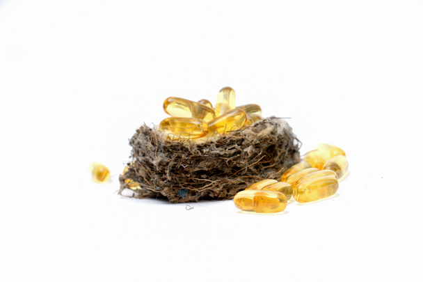 Kabeljauw lever olie omega-3 gel capsules in sparrow nest - Foto, afbeelding