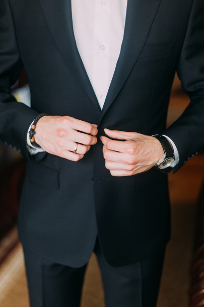 Portrait of a young elegant business closing his tuxedo - Фото, зображення