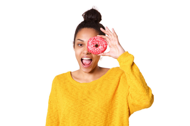 Εύθυμη νεαρή γυναίκα κοιτάζει μέσα από ένα ντόνατ - Φωτογραφία, εικόνα