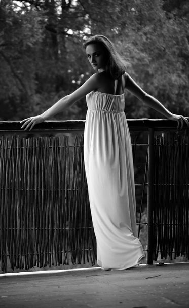 Uma mulher bonita. Jovem mulher bonita vestindo um vestido branco em um p
 - Foto, Imagem