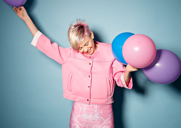 kız mavi arka plan üzerinde renkli balonlar ile iyi eğlenceler - Fotoğraf, Görsel