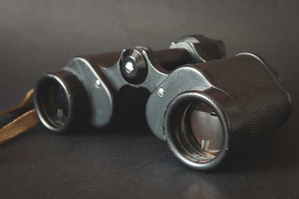 Old binoculars on black background - Foto, afbeelding