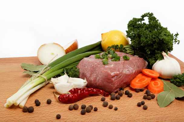 Carne crua, legumes e especiarias isolados em uma mesa de madeira
. - Foto, Imagem
