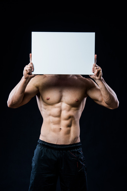 Full isolated studio picture from a young naked man with white sign board. - Photo, Image