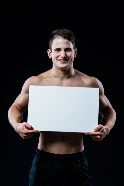 Immagine studio completamente isolato da un giovane uomo nudo con cartello bianco
. - Foto, immagini