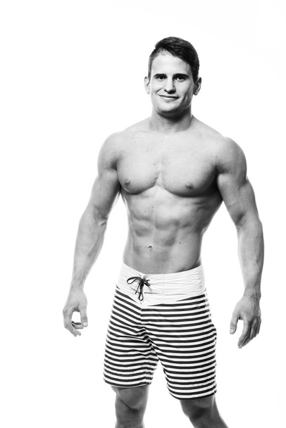 Uomo atletico sexy mostrando corpo muscolare e addominali sixpack, isolato su sfondo bianco. Un busto robusto, maschio, incastrato. Monocromatico foto
. - Foto, immagini