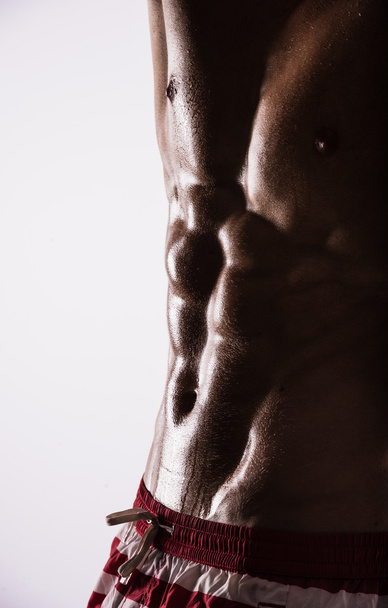 Sylwetka boczna mięśni athletic sexy shirtless gorące młodzieńca pozowanie wyświetlone mokrych sportu ciało z fajne abs piersiowych mięśni piersi silny biceps studio na biały. Perełki potu do ćwiczeń. - Zdjęcie, obraz