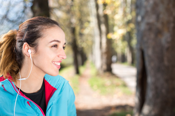 Successful female athlete doing positive  and wearing earphones  - Foto, Bild