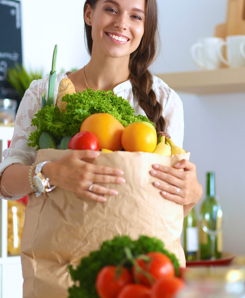 Young woman holding grocery shopping bag with vegetables and fruit - Фото, зображення