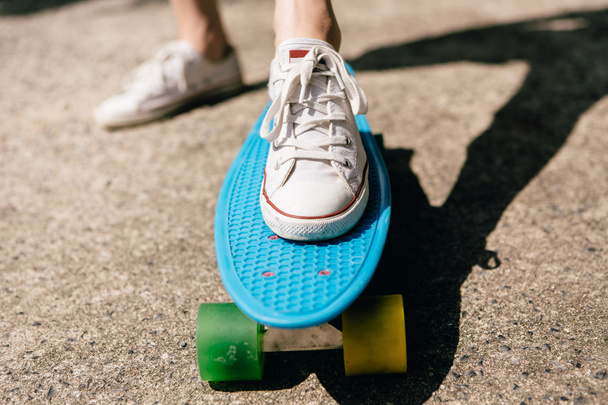 Young girl in sneakers on skateboard. - 写真・画像