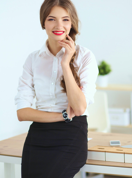 Attractive businesswoman with her arms crossed  standing in off - Fotó, kép