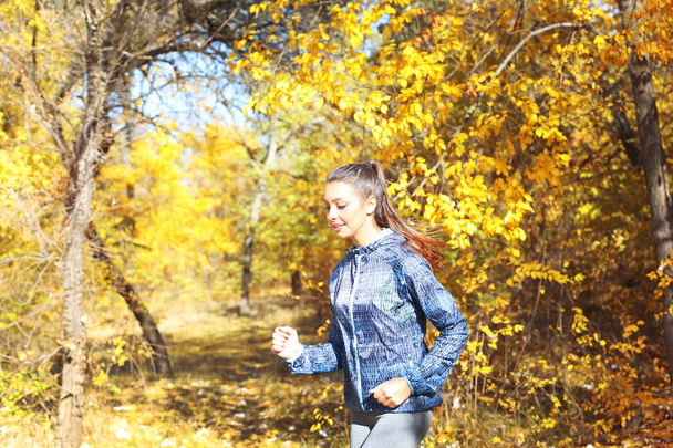 Woman jogging in autumn park - Foto, Imagen