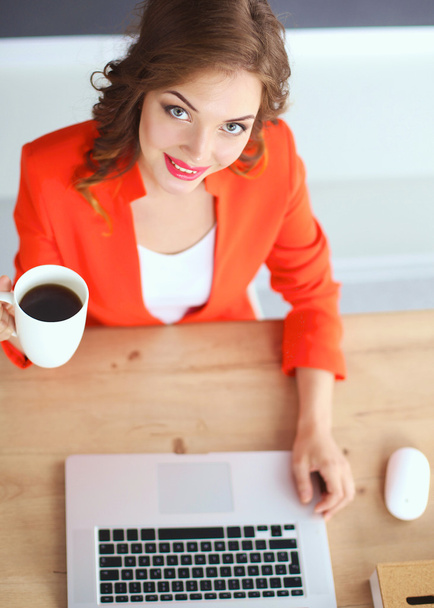 Attractive woman sitting at desk in office, working with laptop - Foto, Imagem