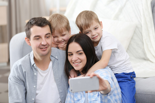 Happy family making selfie on couch background - Фото, изображение