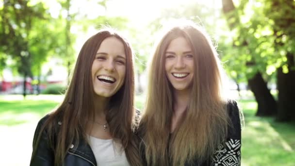 twee jonge vrouwen in het stadspark lachen - Video