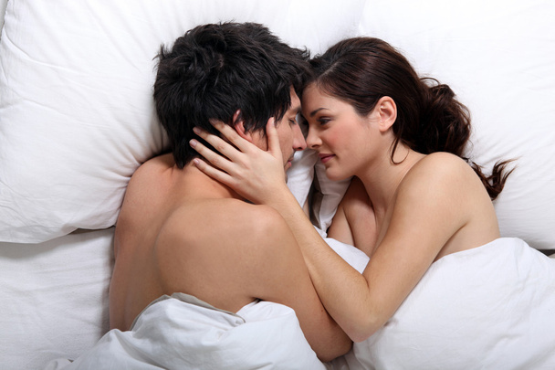 Affectionate couple kissing in bed - Φωτογραφία, εικόνα