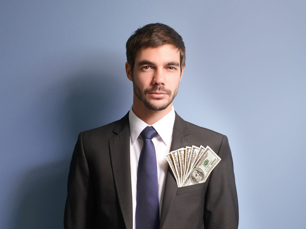 Man in a suit holding dollar banknotes - Valokuva, kuva
