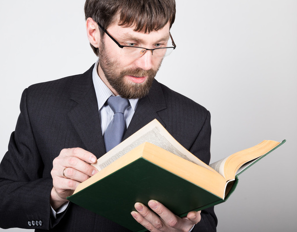 hombre de negocios barbudo en un traje de negocios y corbata, leyendo un libro grueso
 - Foto, imagen