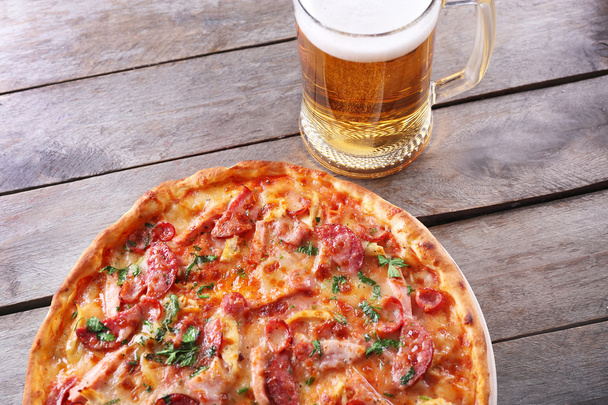 Pizza saborosa e copo de cerveja
  - Foto, Imagem
