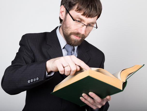hombre de negocios barbudo en un traje de negocios y corbata, leyendo un libro grueso
 - Foto, Imagen