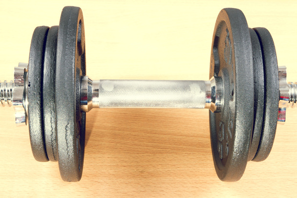 One dumbbell on a wooden floor. - Photo, Image