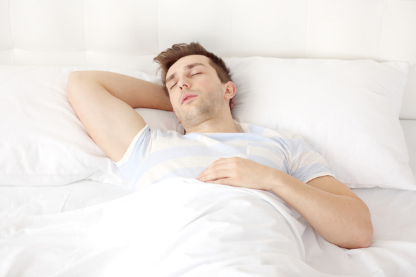 Young man sleeping on bed - Fotoğraf, Görsel