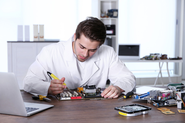 Man repairing electronic circuits - Фото, изображение