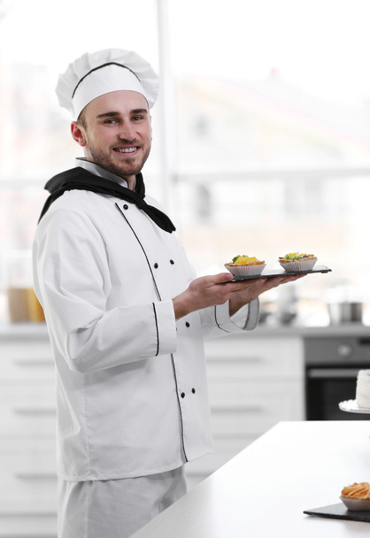 Male chef holding freshly made tarts - Fotoğraf, Görsel