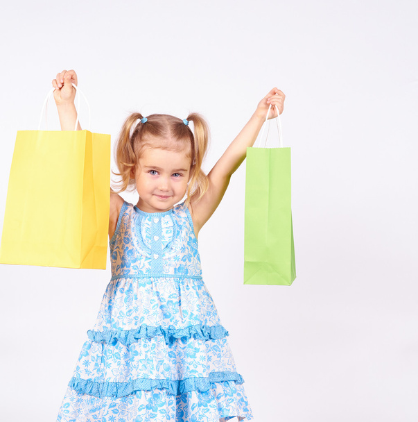 Niño de compras. niña sosteniendo bolsas de compras
 - Foto, imagen