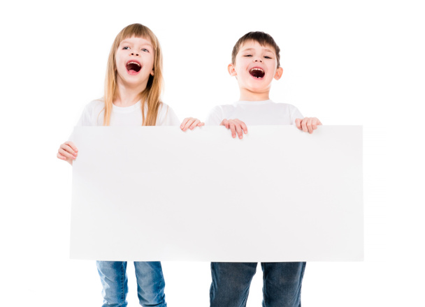 little cute boy and girl holding an empty paper sheet - Fotografie, Obrázek