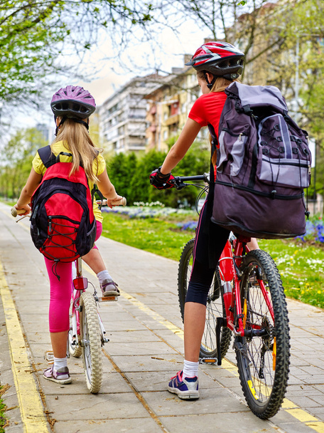 Meisjes kinderen fietsen op gele fietspad. - Foto, afbeelding