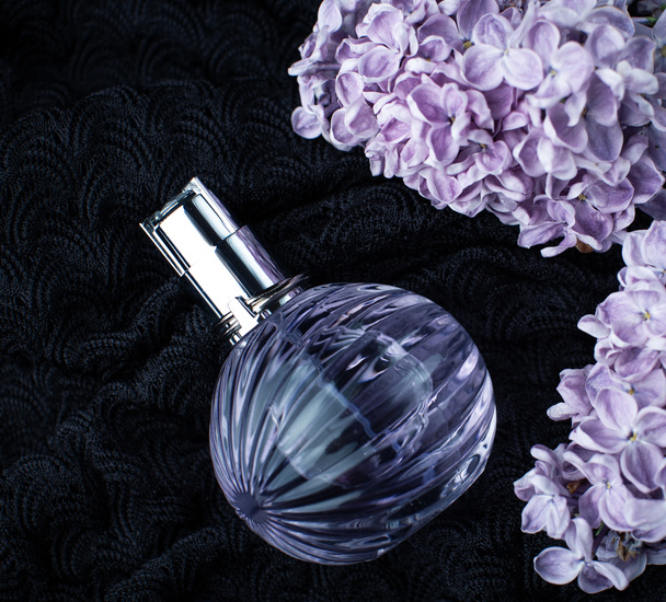 Rama lila cerca de una botella de perfume
 - Foto, imagen