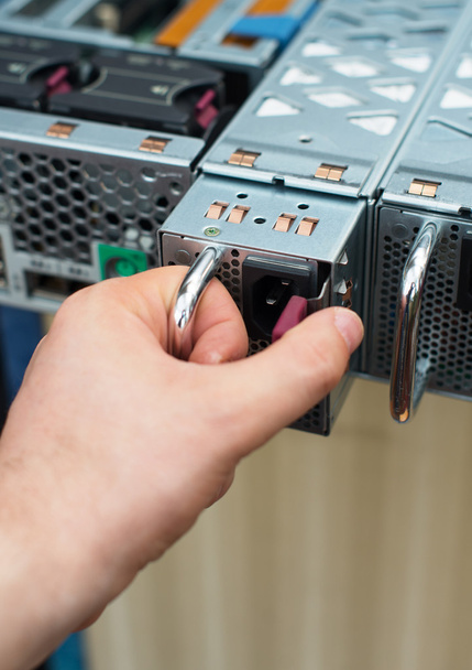 Computer technician installing power supply unit on server. - Photo, Image