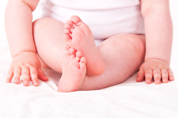 Newborn baby feet on white sofa.  - Fotó, kép